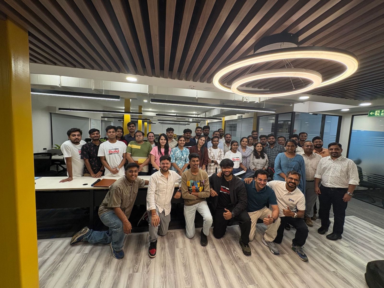 Group photo of Masai learners and mentors in a modern office